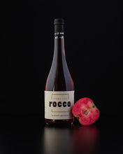 Laden Sie das Bild in den Galerie-Viewer, Weinkeller Hohenbrunn: Bild einer Weinflasche mit alholfreiem Apfel-Apreritivo Roco vom Weinsepphof in Lana / Südtirol und eine halbierten rotfleischigem Apfel